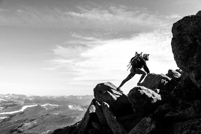 Man climbing mountain black and white